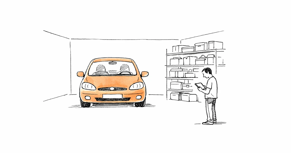 Homme inspectant un garage avec une tablette devant une voiture garée et des étagères de rangement