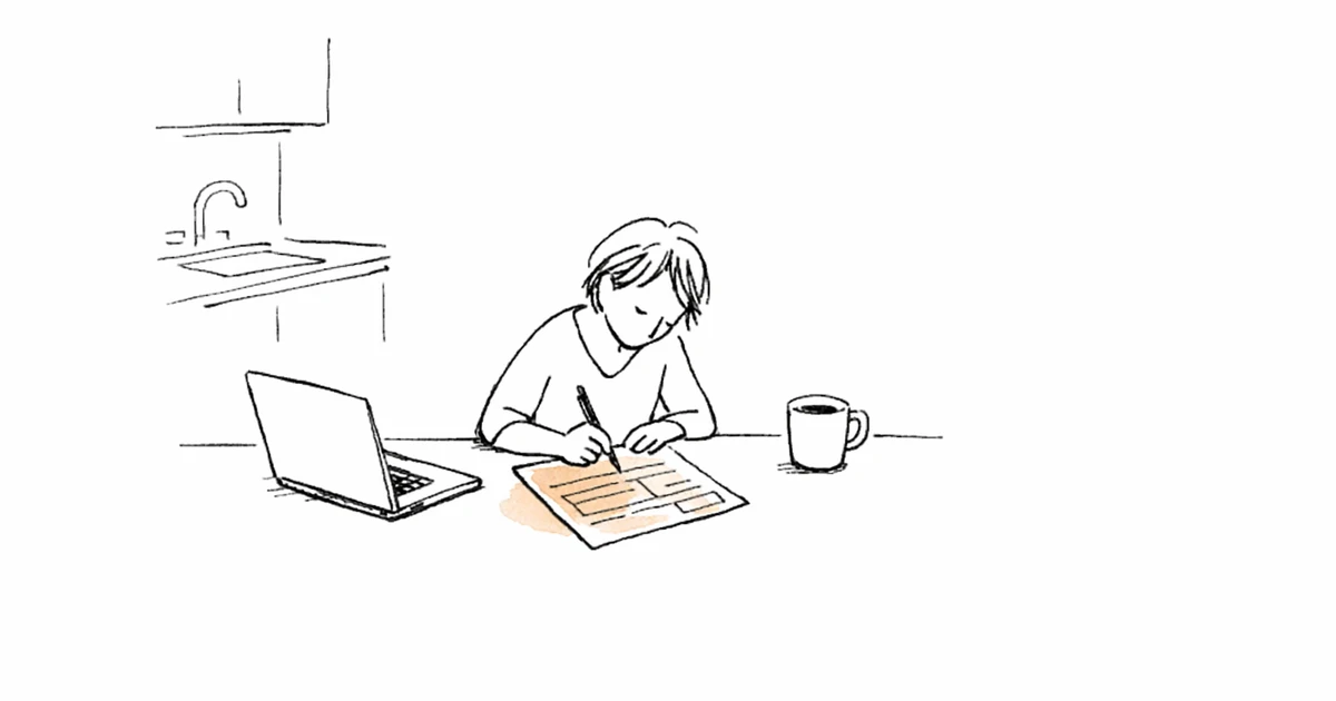 Personne remplissant une quittance de loyer à une table de cuisine avec ordinateur